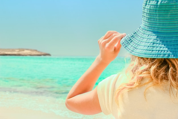 Ragazza felice in cappello in riva al mare sulla natura di Cipro