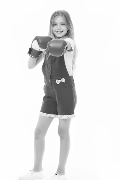 Ragazza felice in guantoni da boxe isolato su bianco Sorriso bambino e boxe Sviluppo e salute dell'infanzia Boxer bambino pronto a combattere Posso difendermi Punzonatura Allenamento e allenamento sportivo