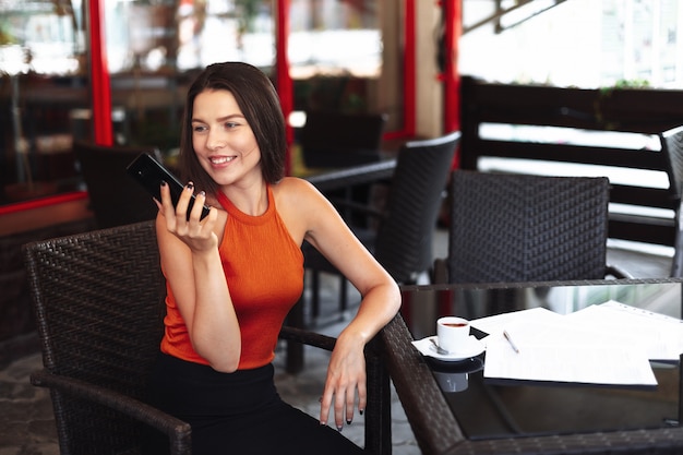 Ragazza felice in un caffè per una tazza di caffè.