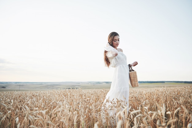 Ragazza felice in un campo di frumento sotto luce solare.