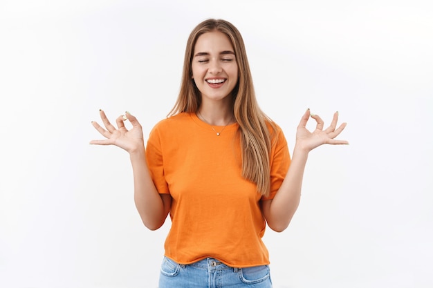 Ragazza felice sollevata che prova la meditazione durante il blocco del covid-19