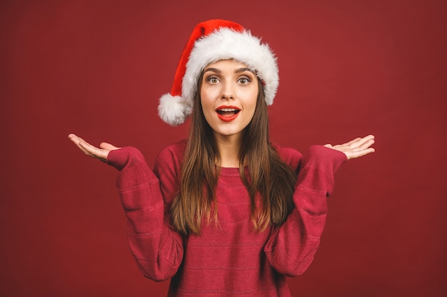 Ragazza felice sorridente in cappello della Santa di Natale