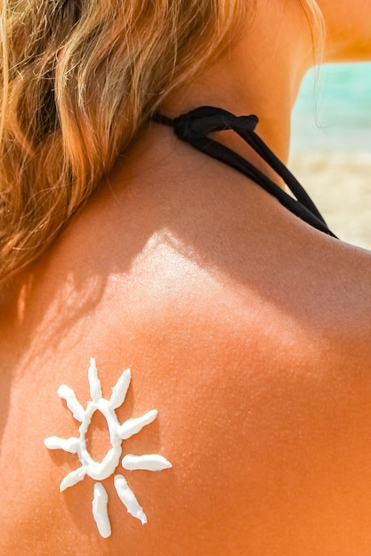 Ragazza felice sul mare con una foto del sole sulla schiena