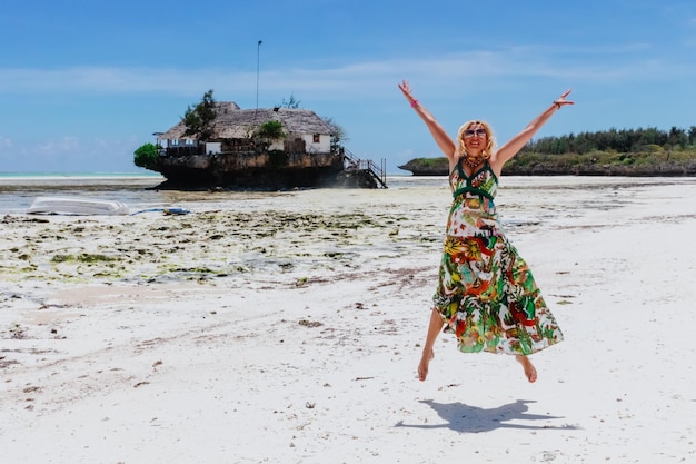 Ragazza felice vicino al famoso rock cafe sulla costa occidentale di Zanzibar.