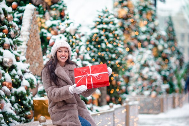 Ragazza felice vicino al ramo dell'abete in neve per il nuovo anno.