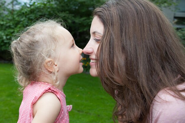 Ragazza figlia donna e bambino su sfondo verde nel concetto di vacanza in famiglia primaverile