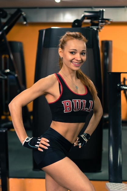 Ragazza fitness con un bel sorriso in posa in palestra