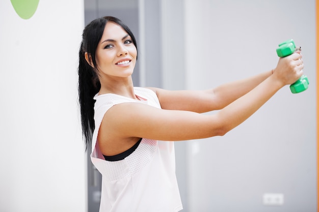 Ragazza fitness. Ragazza atletica sexy che risolve in palestra. Donna fitness facendo esercizio