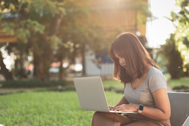 Ragazza freelance asiatica che lavora con un computer portatile.