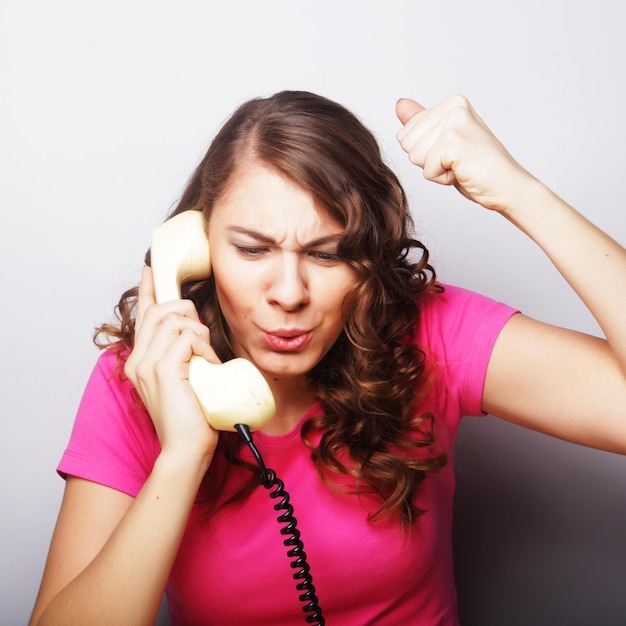 Ragazza furiosa con telefono vintage