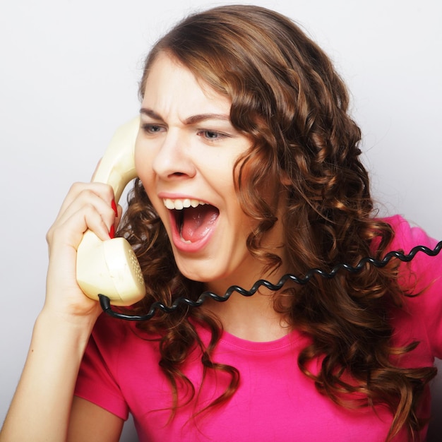 Ragazza furiosa con telefono vintage