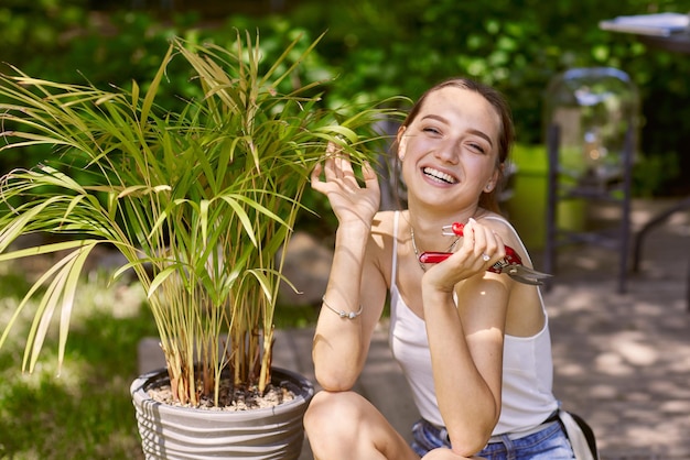 Ragazza giardiniere che si prende cura delle piante con un sorriso