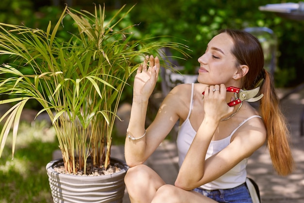 Ragazza giardiniere che si prende cura delle piante con un sorriso