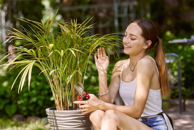 Ragazza giardiniere che si prende cura delle piante con un sorriso