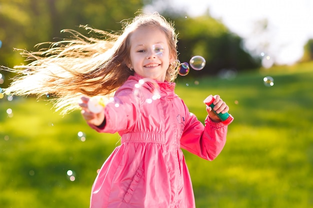 Ragazza gioca con le bolle di sapone.