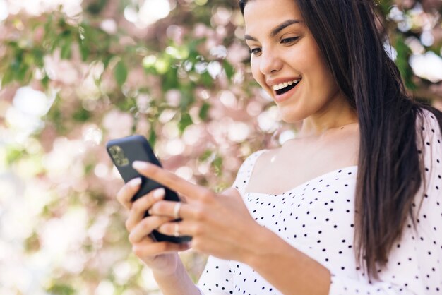 ragazza gioiosa che legge buone notizie al telefono signora sorpresa che celebra la vittoria al telefono