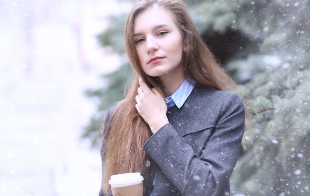 Ragazza giovane all'aperto in inverno. Ragazza modello in posa all'aperto in una giornata invernale. Fine settimana festivo nella ragazza che cammina per strada.