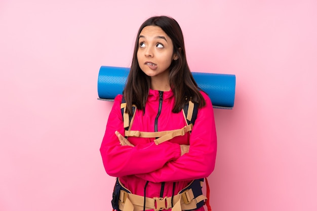 Ragazza giovane alpinista con un grande zaino isolato