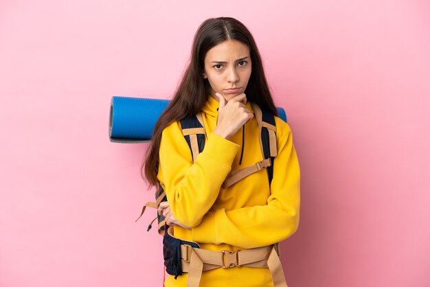 Ragazza giovane alpinista con un grande zaino isolato