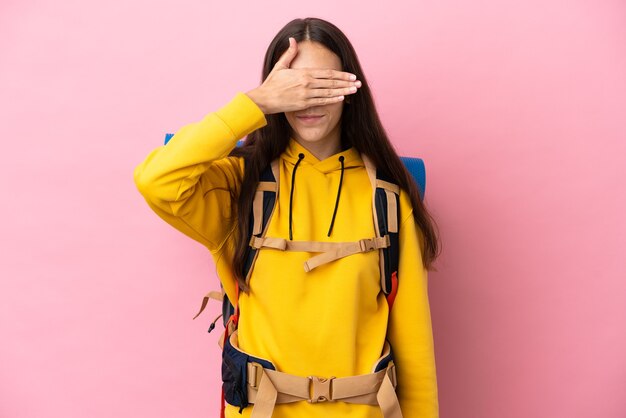 Ragazza giovane alpinista con un grande zaino isolato