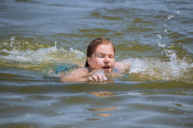 Ragazza giovane che nuota nell'oceano con gli occhi chiusi concetto di vacanza