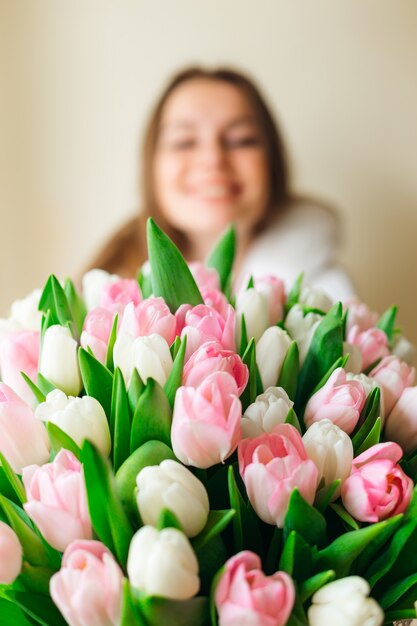 Ragazza giovane con bouquet di fiori primaverili nelle sue mani. Concetto di giorno di madri.