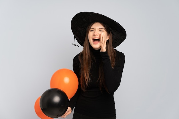 Ragazza giovane con cappello nero e abito nero azienda ballons