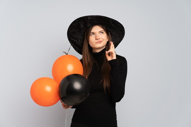 Ragazza giovane con cappello nero e abito nero azienda ballons