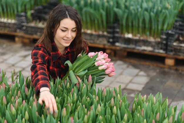 Ragazza giovane, operaio con fiori in serra