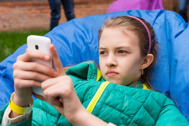 Ragazza giovane rilassante controllando il suo cellulare