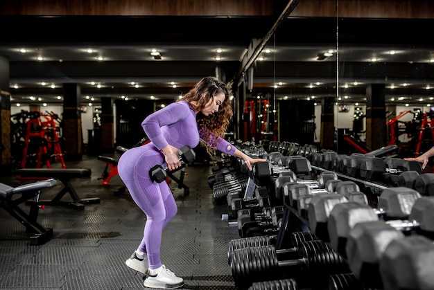 Ragazza giovane sollevamento pesi in palestra. concetto di stile di vita sano