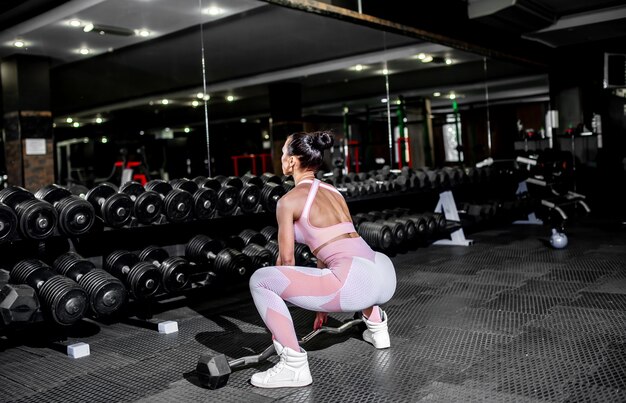 Ragazza giovane sollevamento pesi in palestra