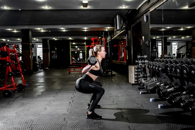 Ragazza giovane sollevamento pesi in palestra