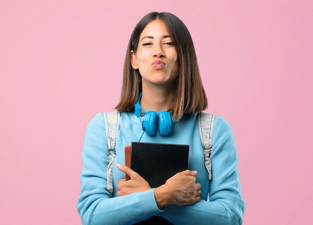 Ragazza giovane studente con maglione blu e cuffie. di nuovo a scuola