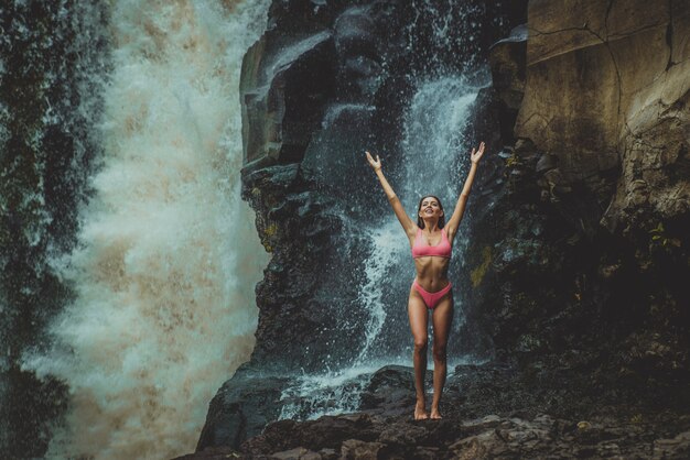 Ragazza graziosa alla cascata di Tegenungan, Bali