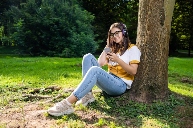 Ragazza graziosa allegra che ascolta il