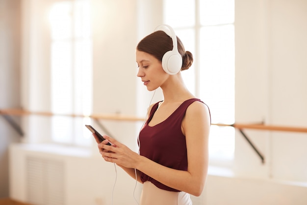 Ragazza graziosa che sceglie pista per prepararsi