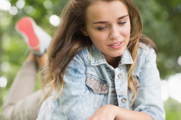 Ragazza graziosa che si trova sull&#39;erba