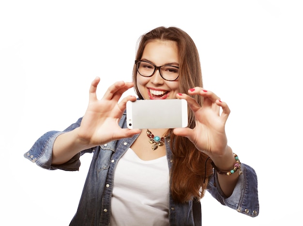 Ragazza graziosa dei pantaloni a vita bassa che prende selfie Concetto di stile di vita giovane e felice