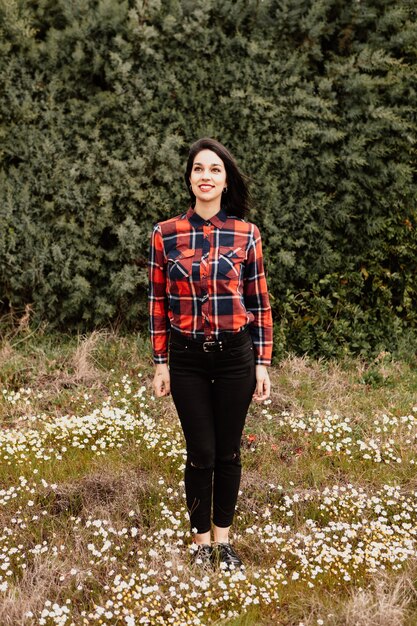 Ragazza graziosa del brunette con la camicia di plaid rossa