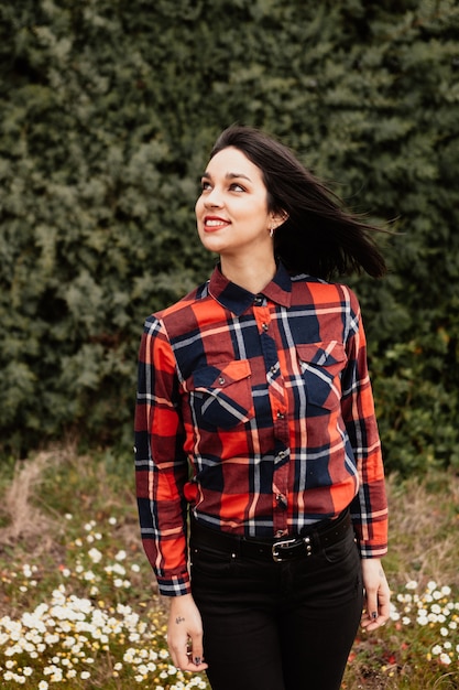 Ragazza graziosa del brunette con la camicia di plaid rossa