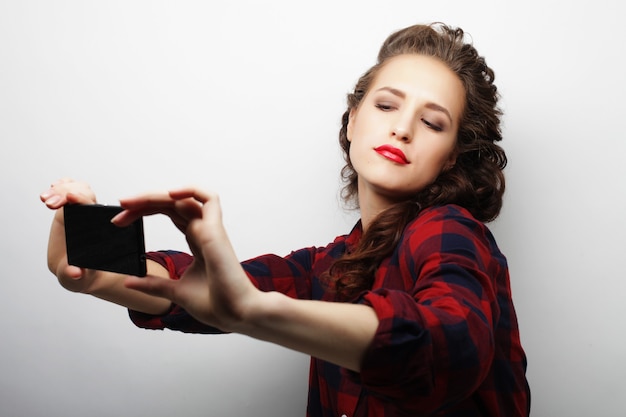 Ragazza graziosa hipster che prende selfie