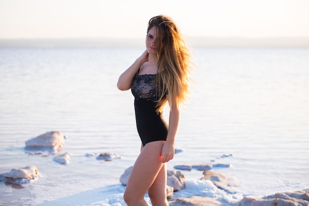 Ragazza graziosa in costume da bagno in spiaggia