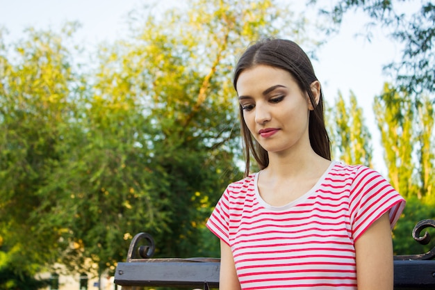 Ragazza graziosa premurosa che si siede da solo all&#39;aperto nel parco