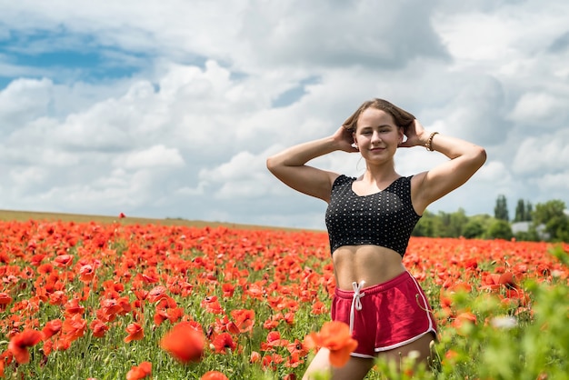 Ragazza graziosa ucraina che gode dei fiori in campagna. Estate