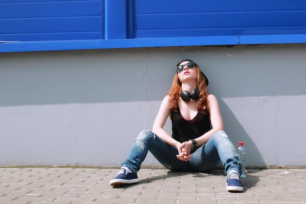 Ragazza hipster al muro blu