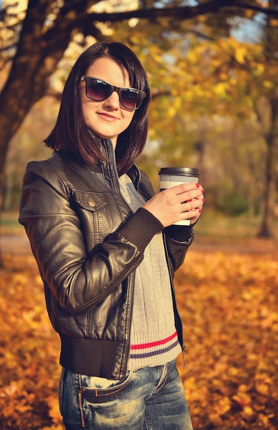 Ragazza hipster che tiene tazza di caffè