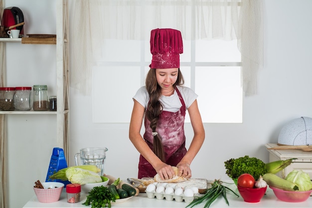 Ragazza il futuro chef sta cucinando cibo sano