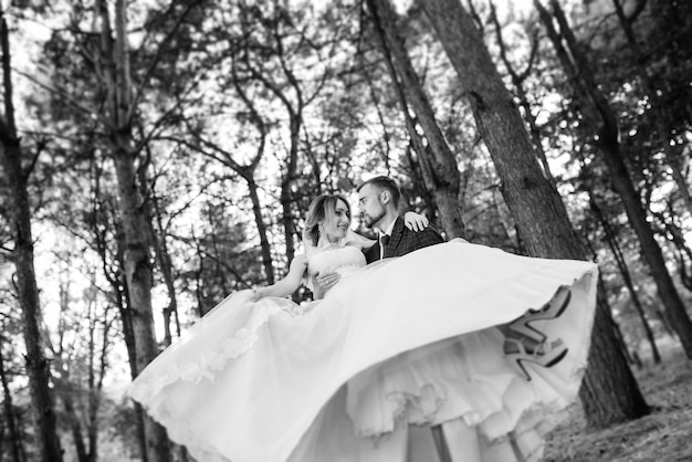 Ragazza in abito da sposa nella foresta autunnale sullo sfondo di alberi selvatici