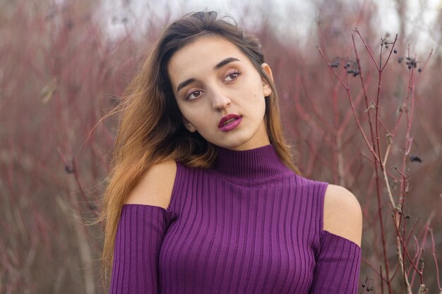 Ragazza in abito lilla sulla natura in autunno Ritratto di una bella ragazza in autunno nella foresta